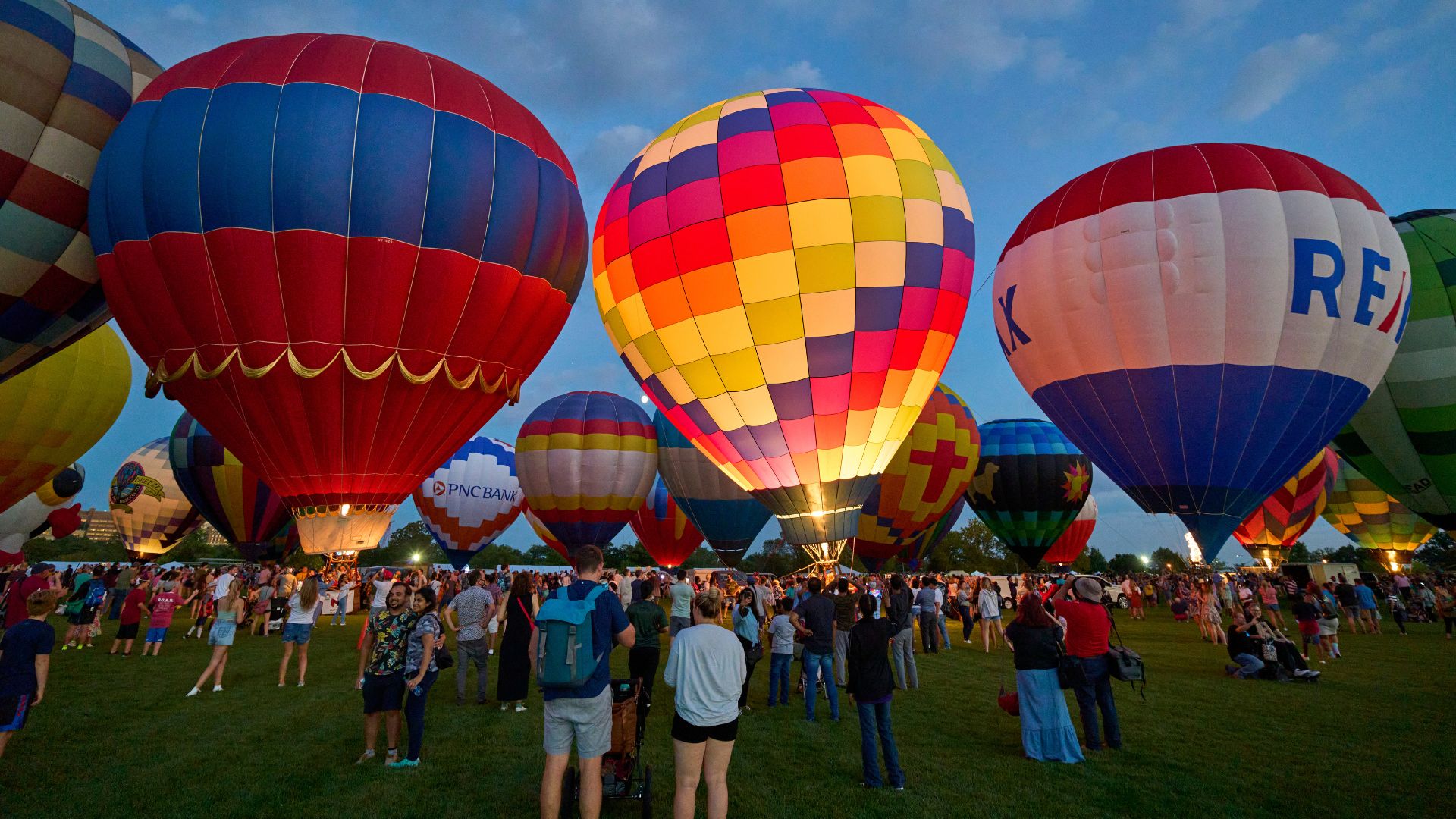 People stand among illuminated hot air balloons at The Great Forest Park Balloon Glow, one of the top things to do in St Louis in September.