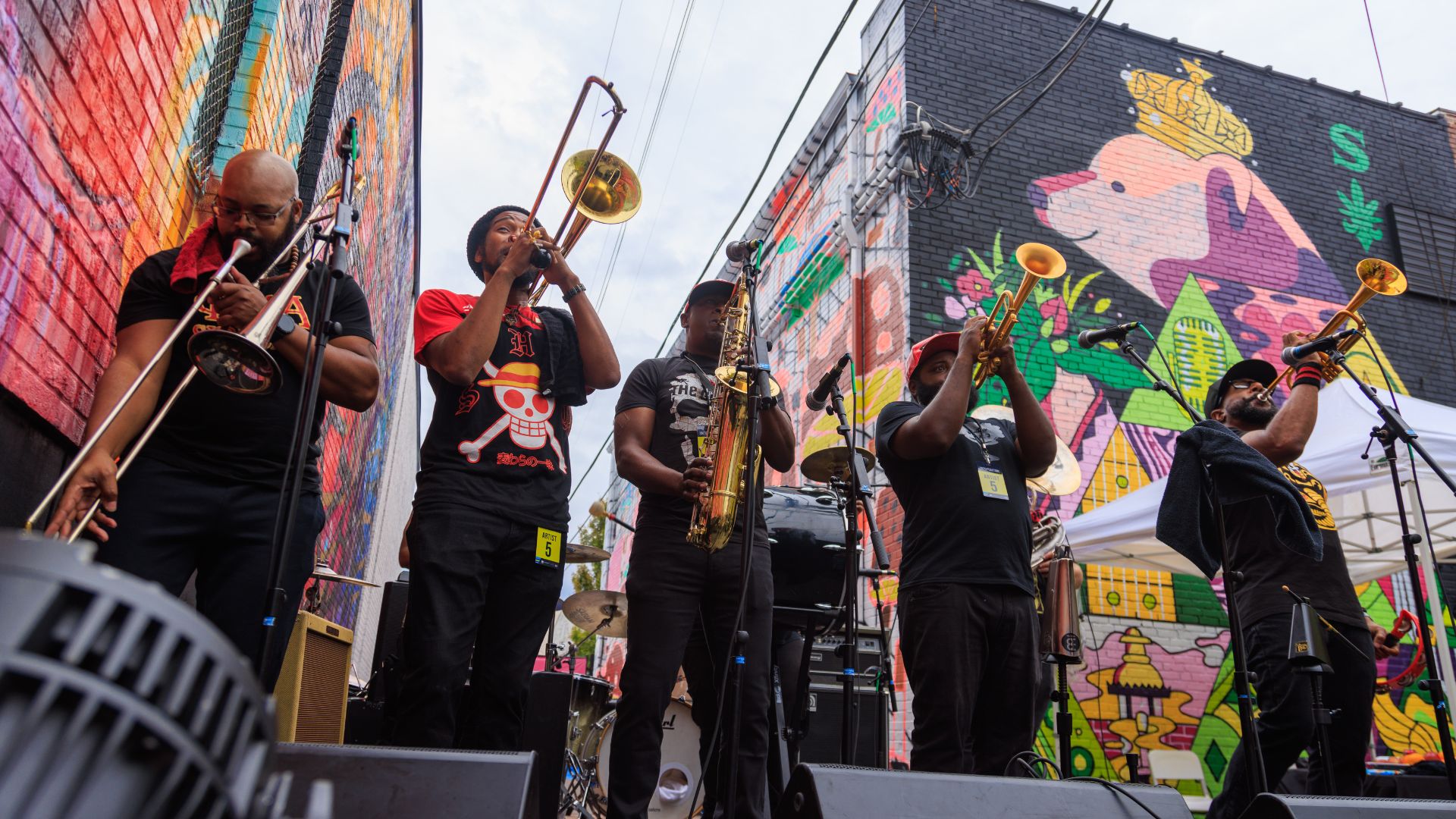 A brass band plays among the murals of Grand Center during Music at the Intersection.