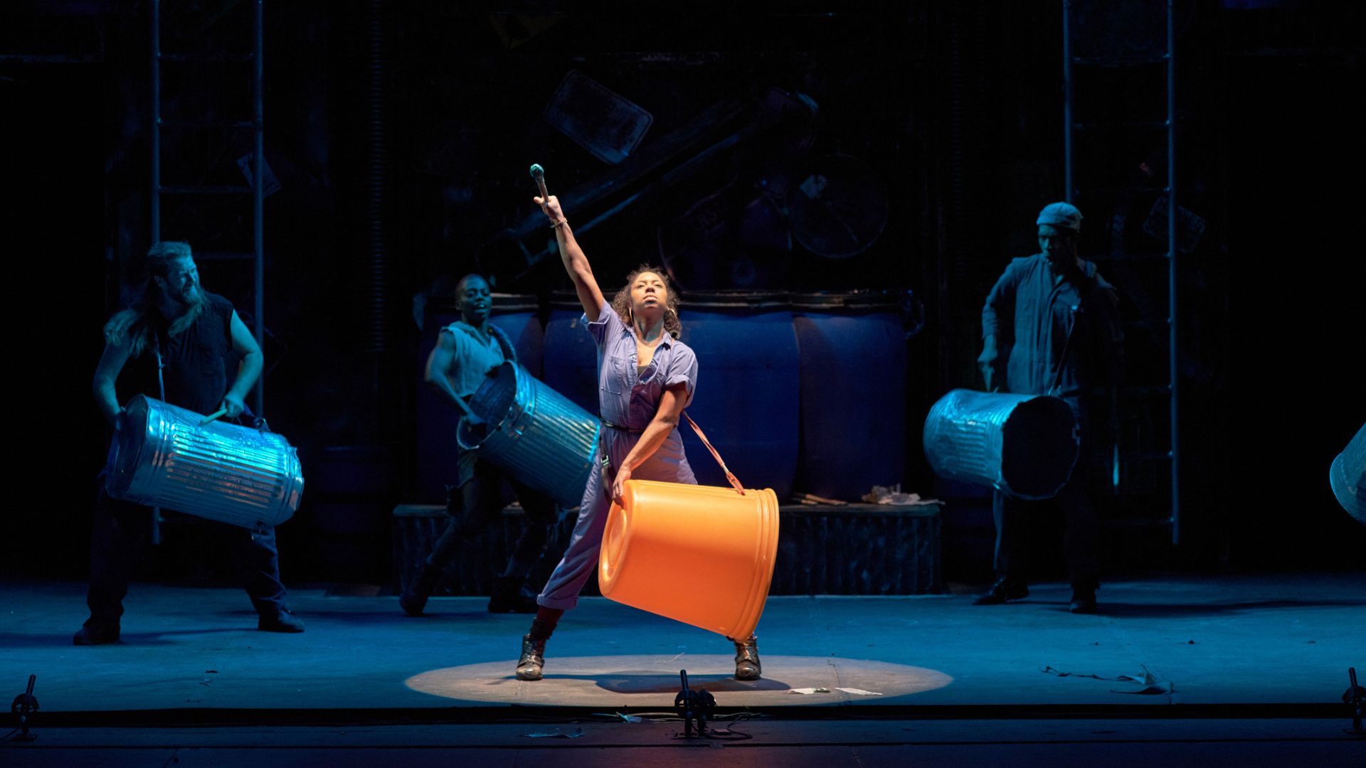 A member of the Stomp ensemble makes noise with a trash can.