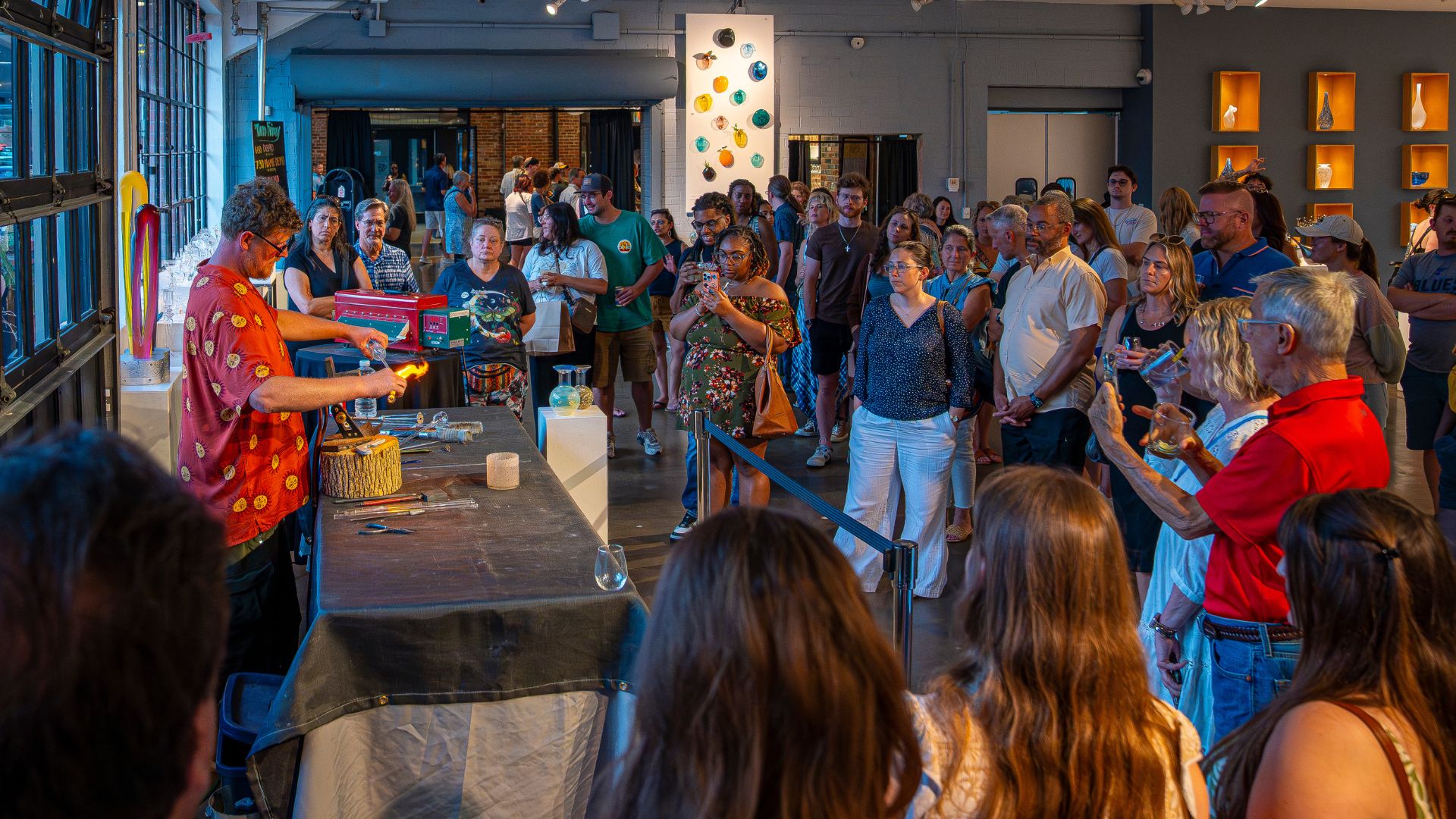 A crowd watches a glassblowing demonstration at Third Degree Glass Factory.