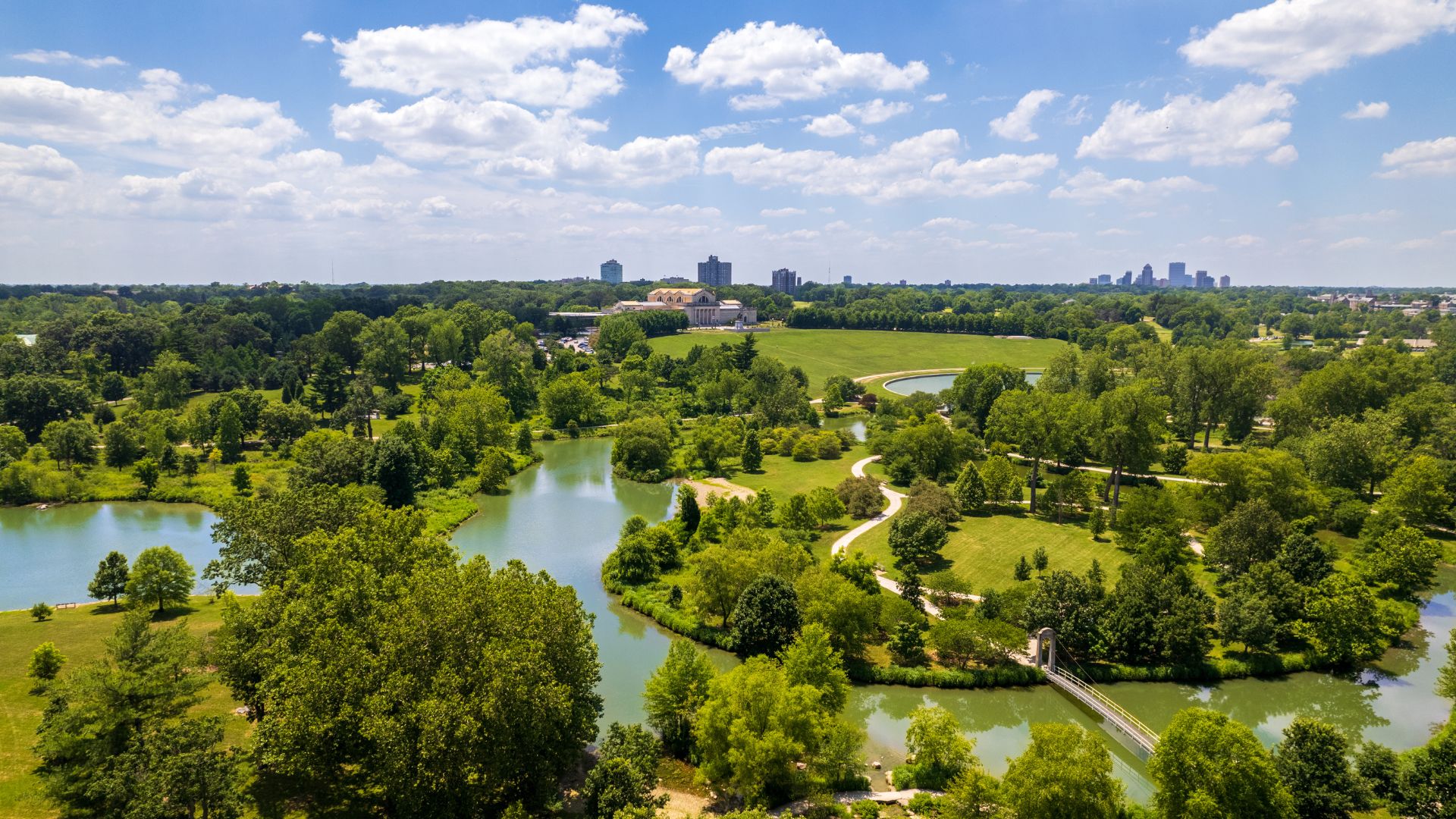 A drone shot shows the greenery and waterways of Forest Park, perfect for birdwatching in St Louis, with the Saint Louis Art Museum in the background.