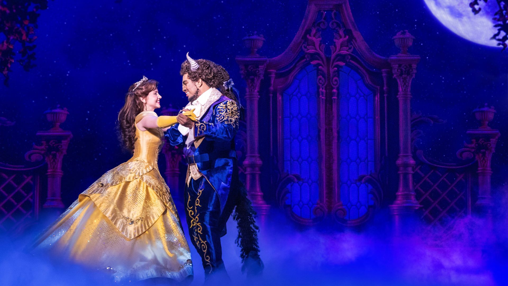 Beauty and the Beast dance across the stage in the Broadway musical.