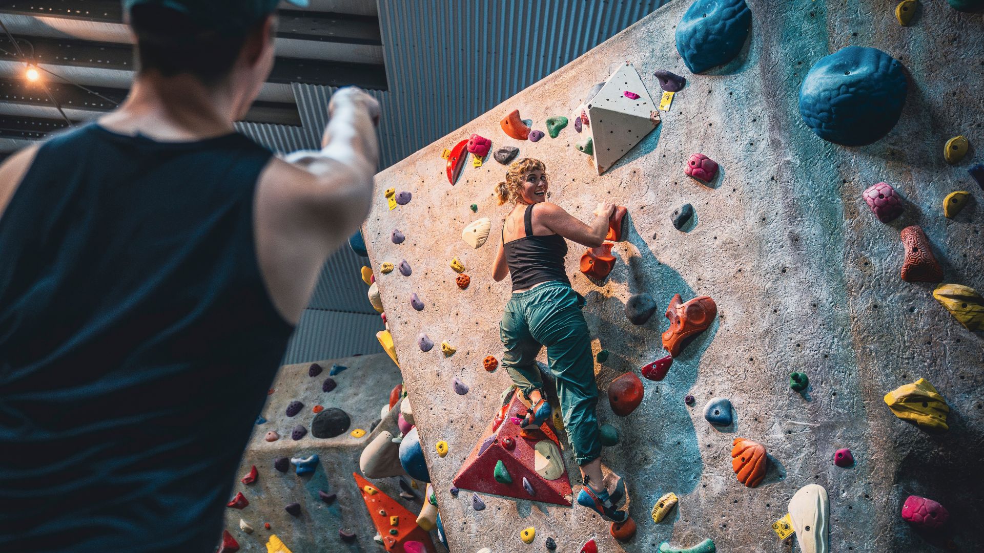 A couple gives each other tips while rock climbing at Upper Limits in St Louis.